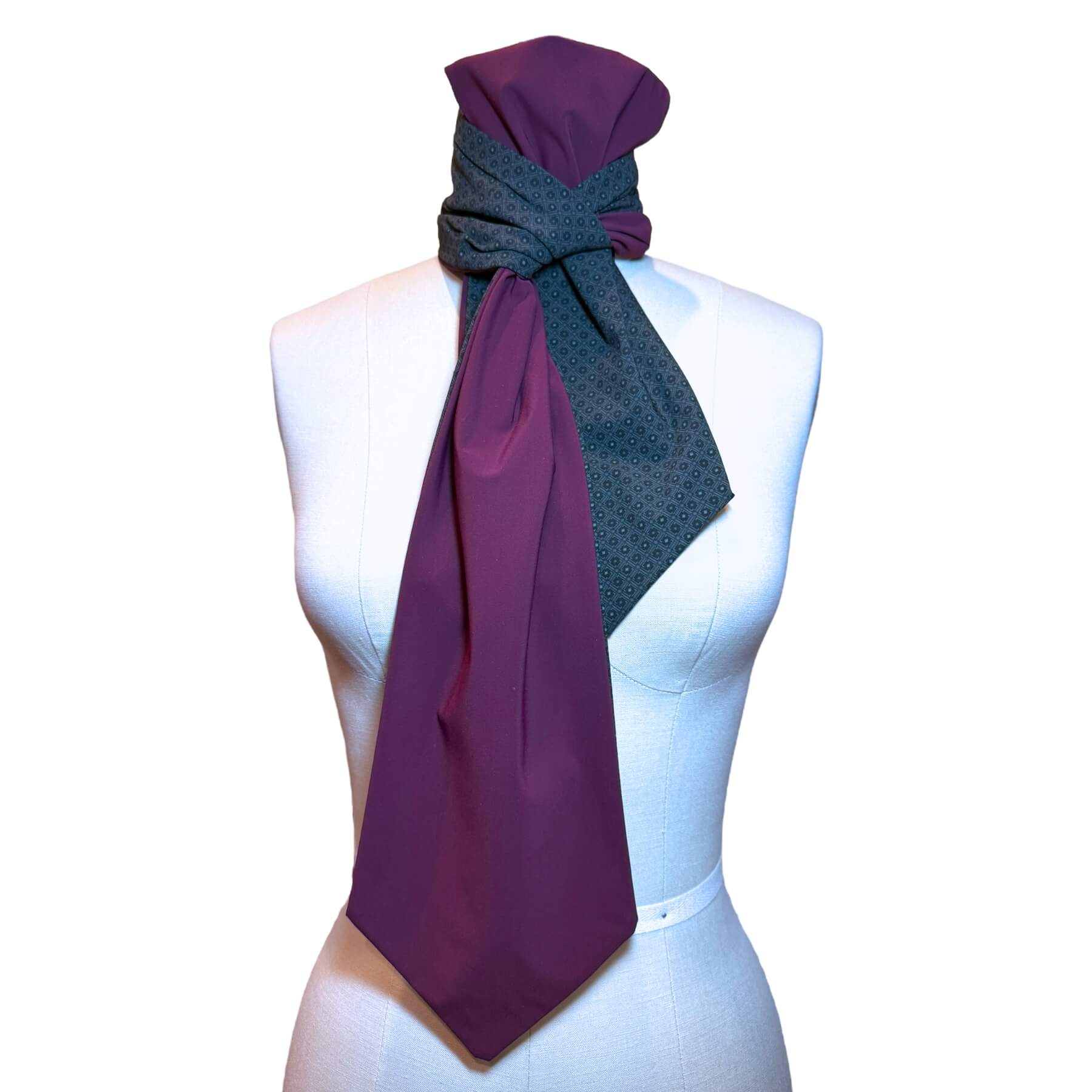 Heliades reversible sun protective scarf shown on mannequin in charcoal gray rosette print with eggplant color on reverse