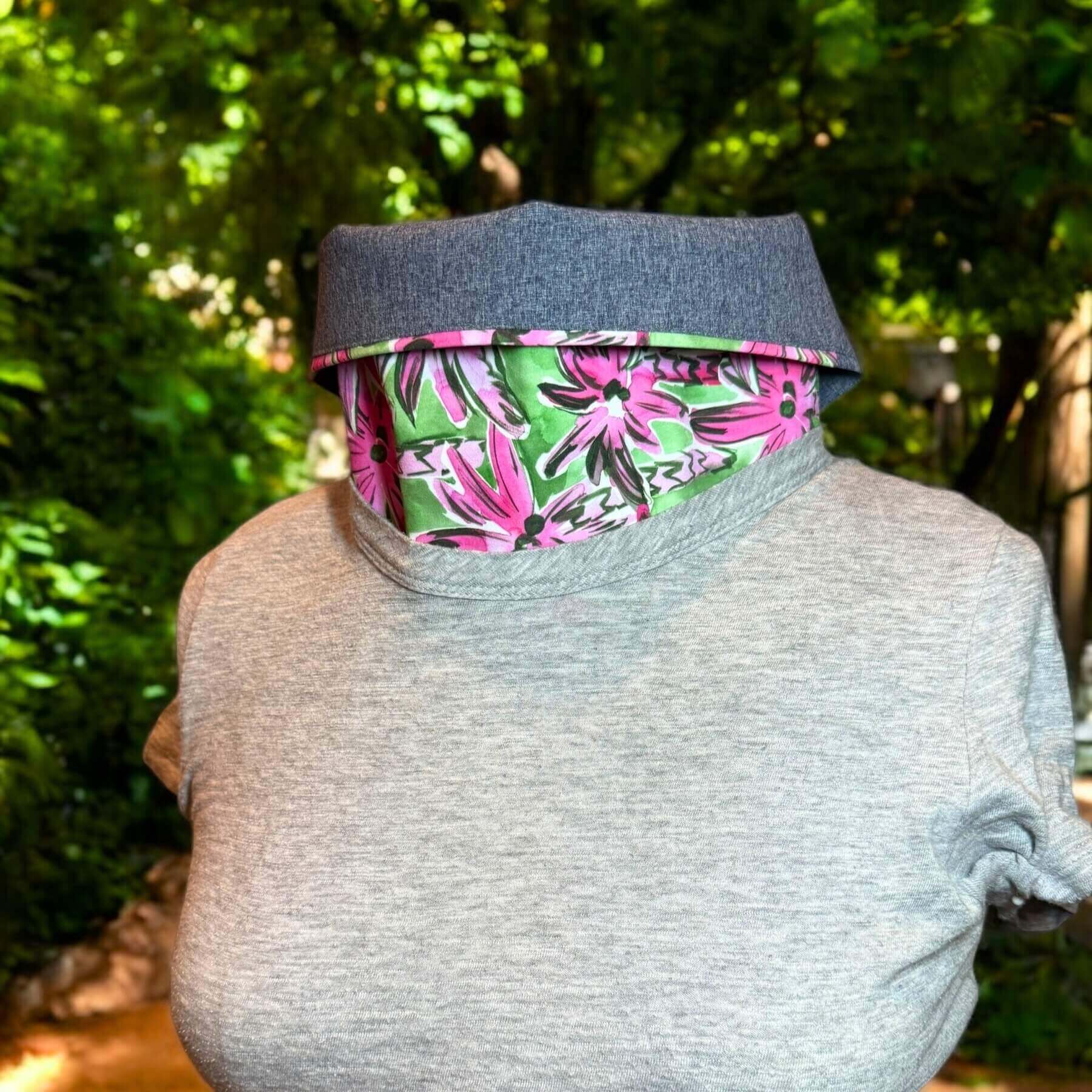 Blue melange, green, pink palm tree print Sun Dickey shown with collar turned down and paired with gray t-shirt from Banana Republic. In background are green trees.