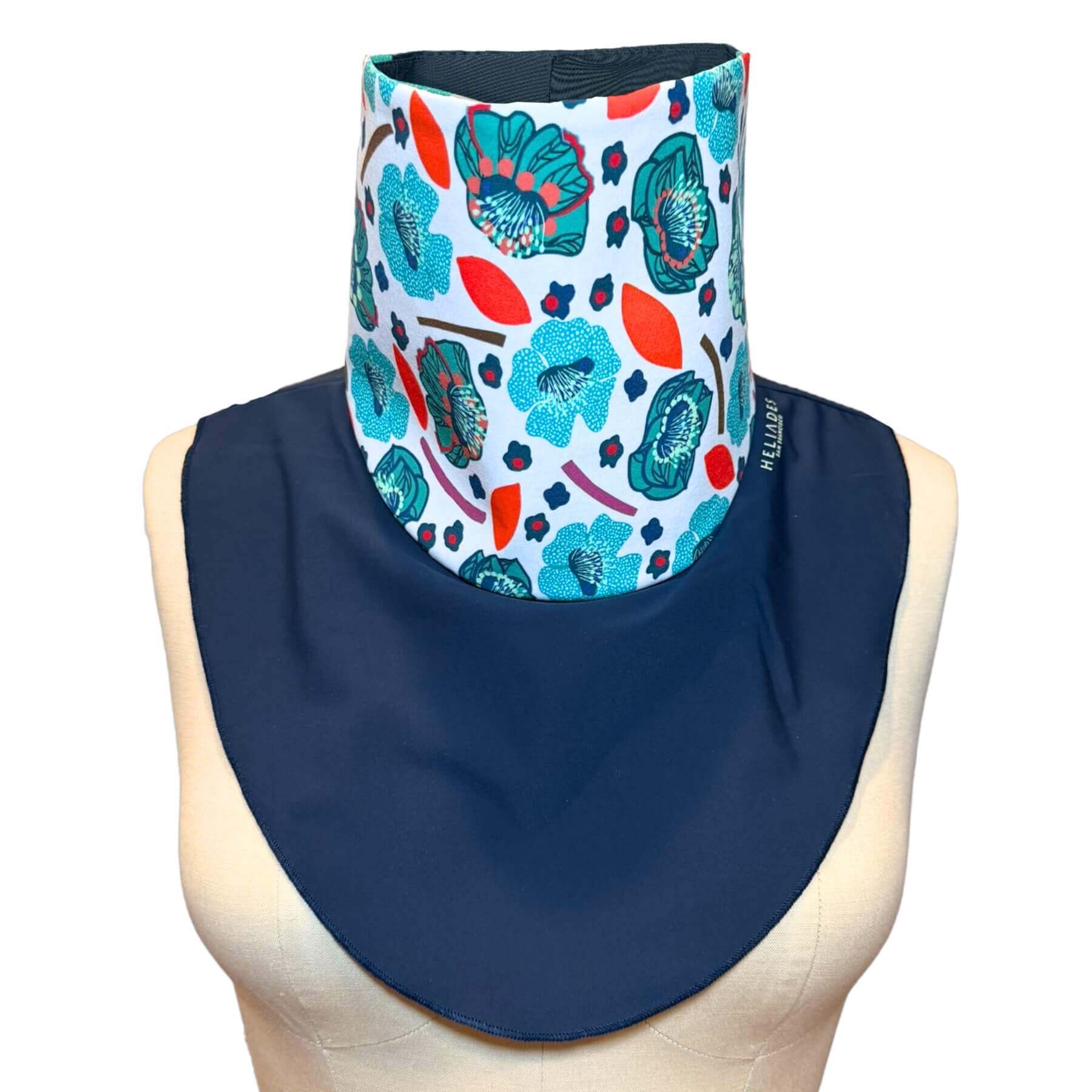 Cute sun neck protector with UPF 50+ protection shown in navy blue with detailed teal, blue, mint and red flower motif on white print.