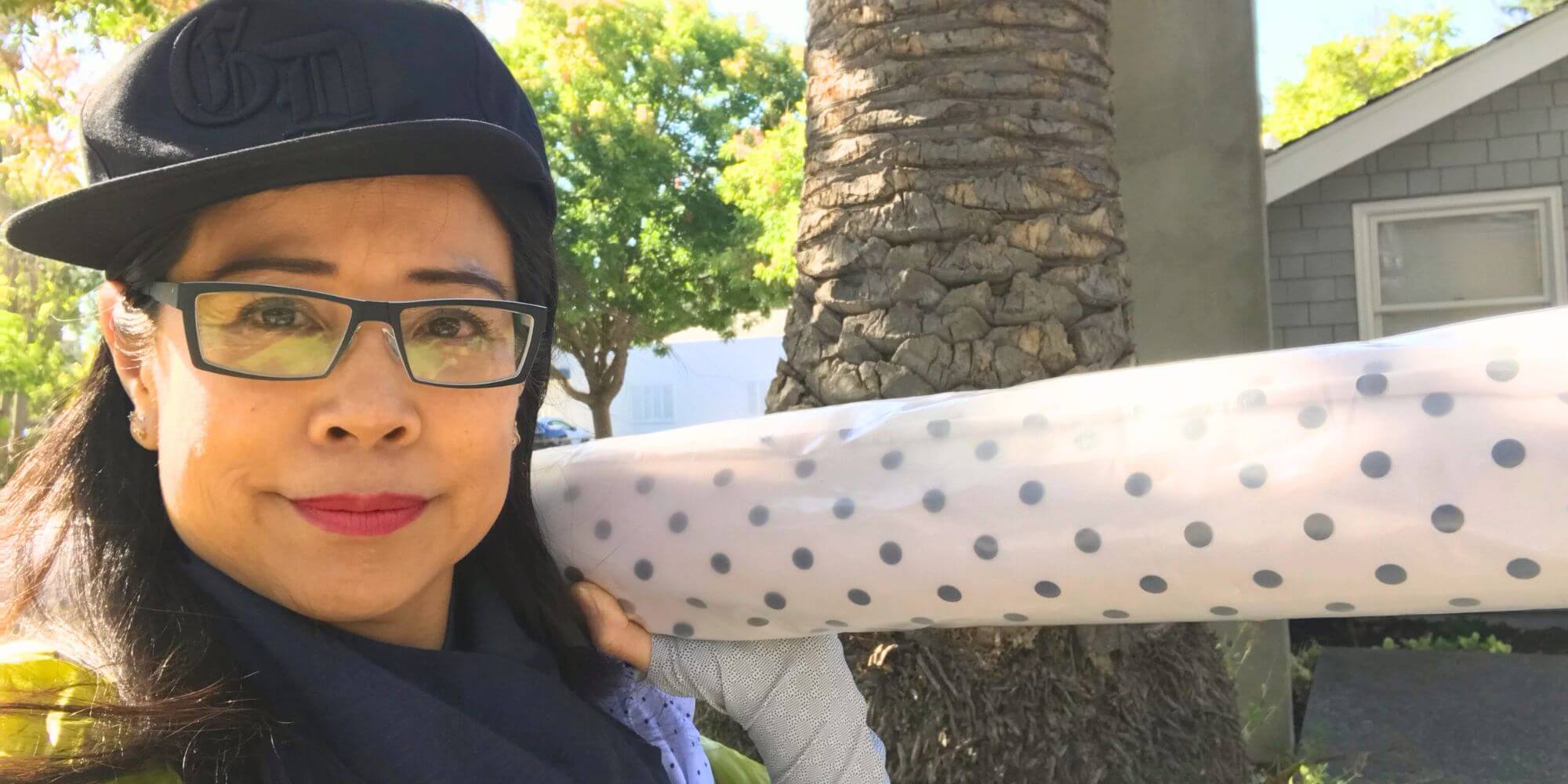 Heliades founder and designer Sharone with UPF50+ fabric, creating style-first sun protective clothing.