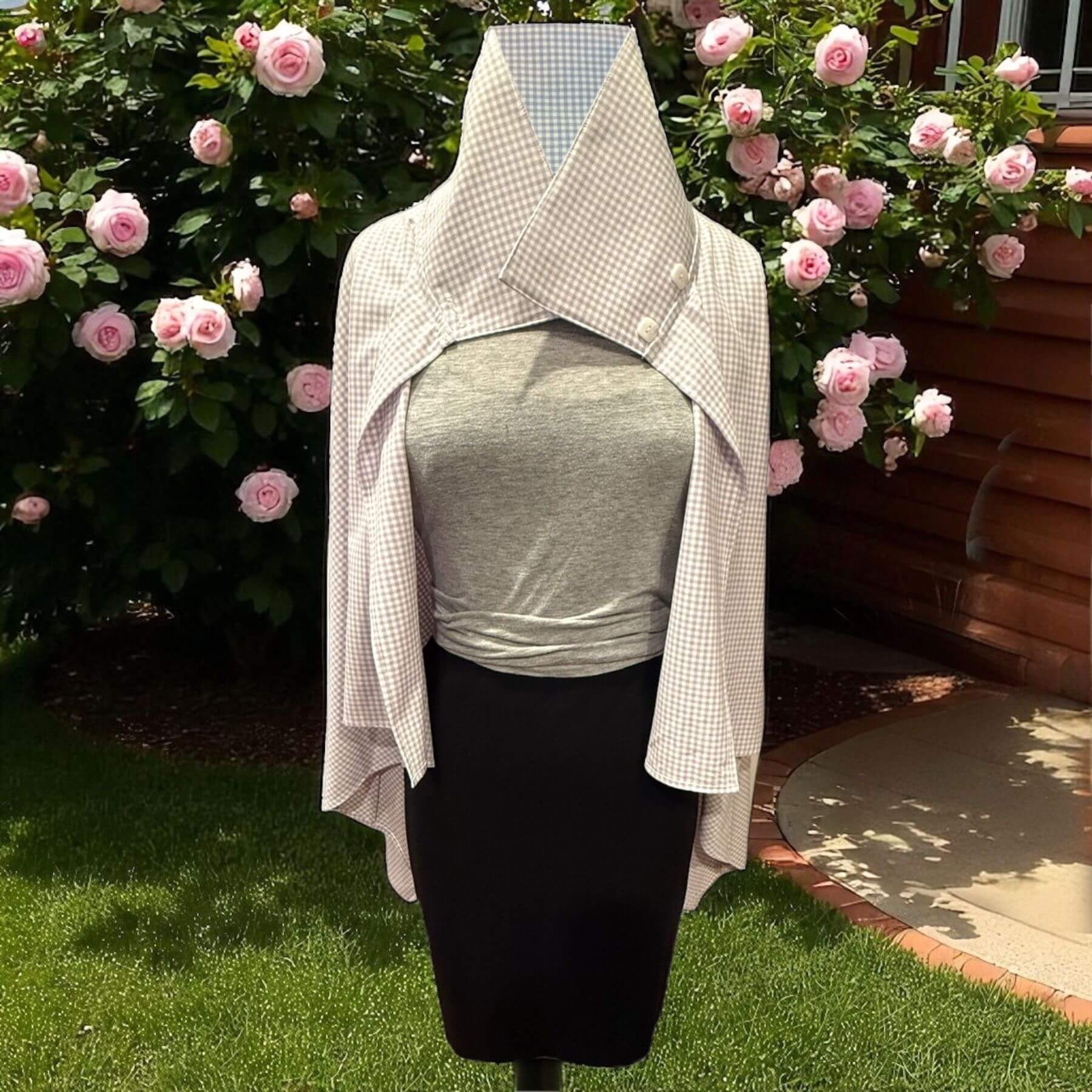 Outdoor view of the Lavender Check Sun Protection Shoulder Wrap on mannequin, buttoned collar style in lightweight UPF 50+ plaid fabric, with rose garden background.