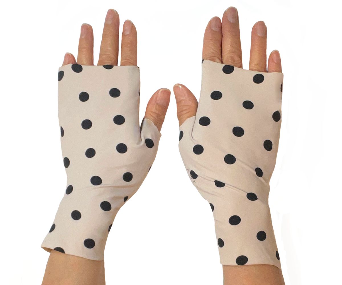 Heliades Sun Protective Clothing lightweight UV sun gloves in stylish patterned UPF 50 fabric. Shown is fashionable polka dot print with ballet pink and black colors. UV sun covered hands shown front