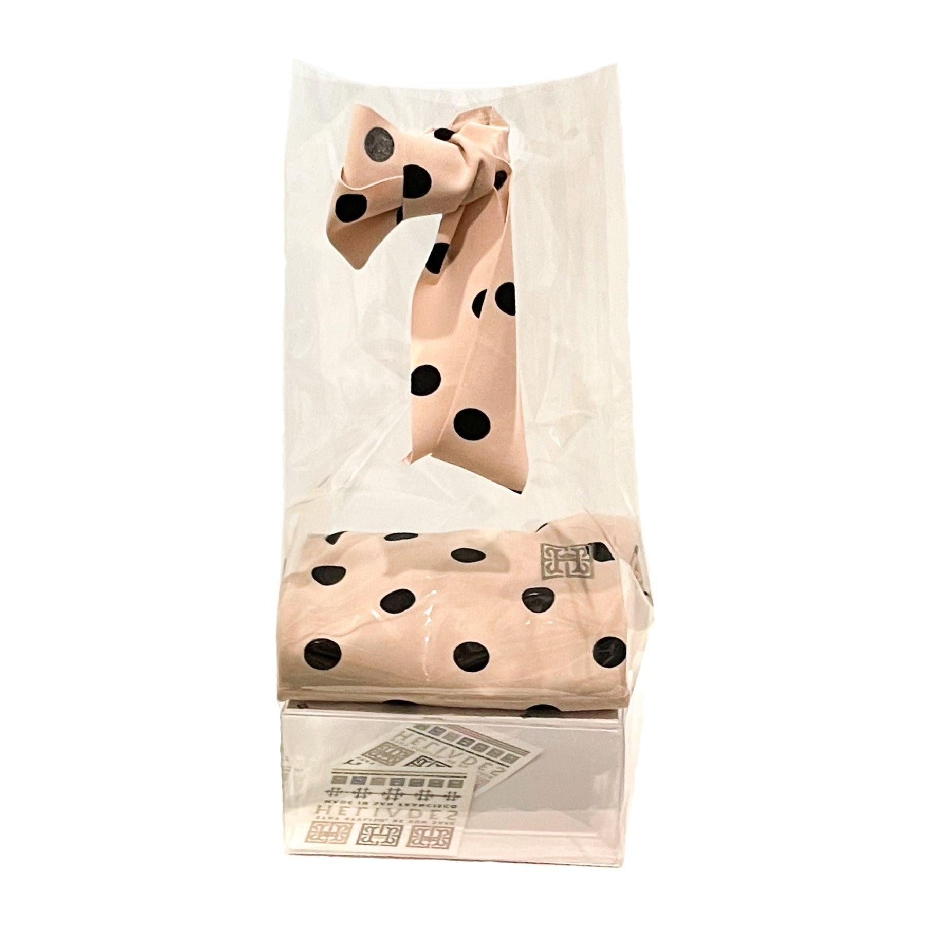 Easy, elegant DIY gift packaging kit shown fully assembled with clear cellophane bag, upcycled fabric ribbon cut from repurposed HELIADES fabric, branded clear packaging insert and two temporary tattoos. Ballet Pink Polka Dot UPF50+ Sun Protective Arm Sleeves sold separately.