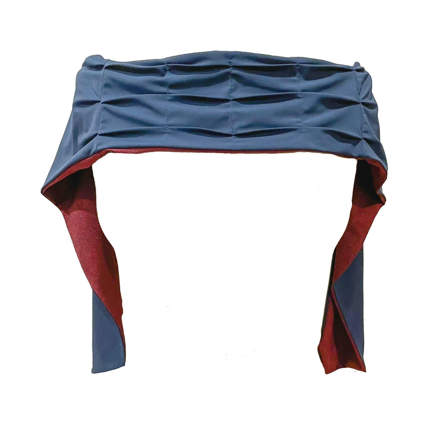 Heliades UPF 50+ Sun Protection scarf shown styled as shawl over shoulders, color is burgundy deep red with gold sparkle pattern, reversible side is true navy blue solid color.