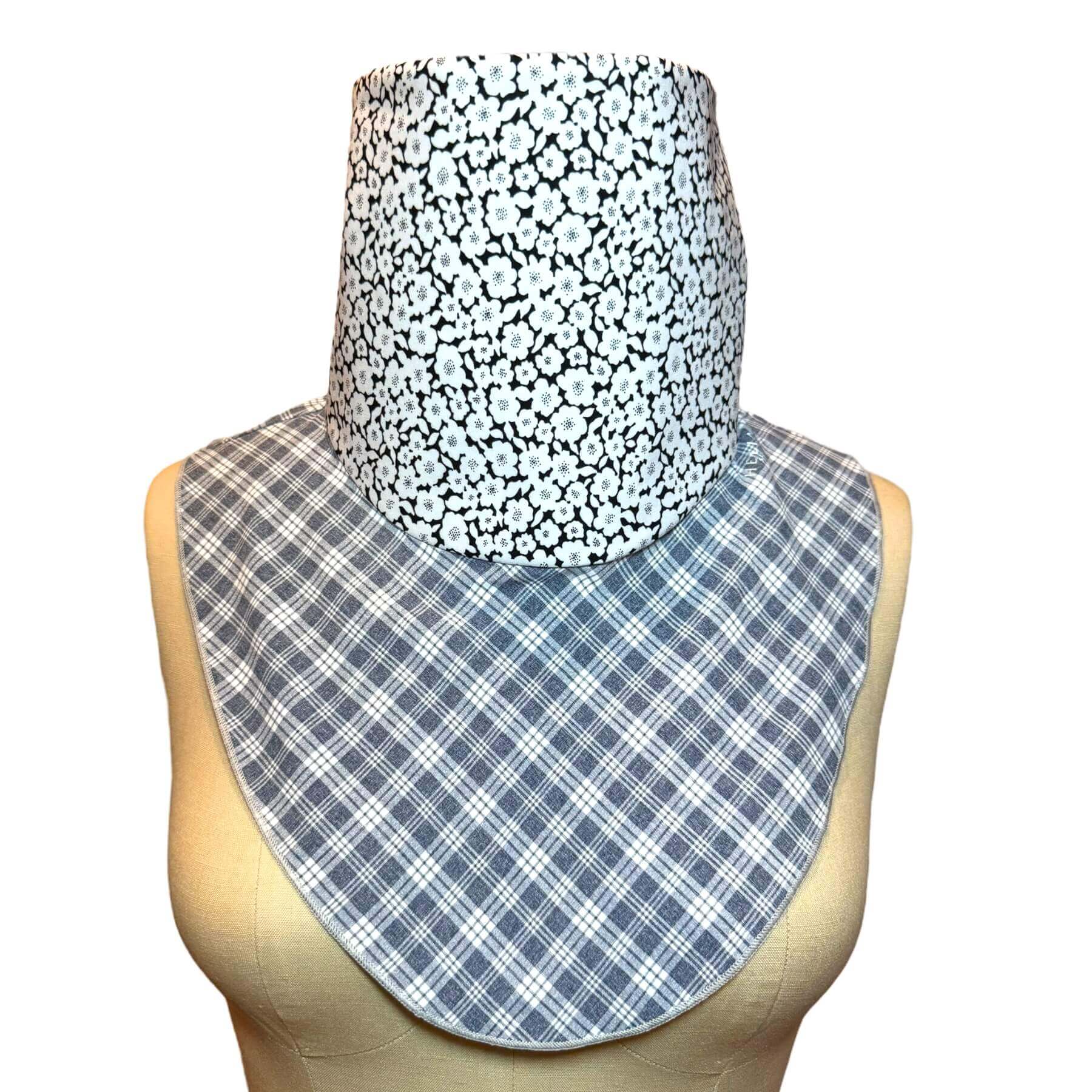 Stylish neck cover from sun exposure shown in gray and white plaid with black, white floral print.