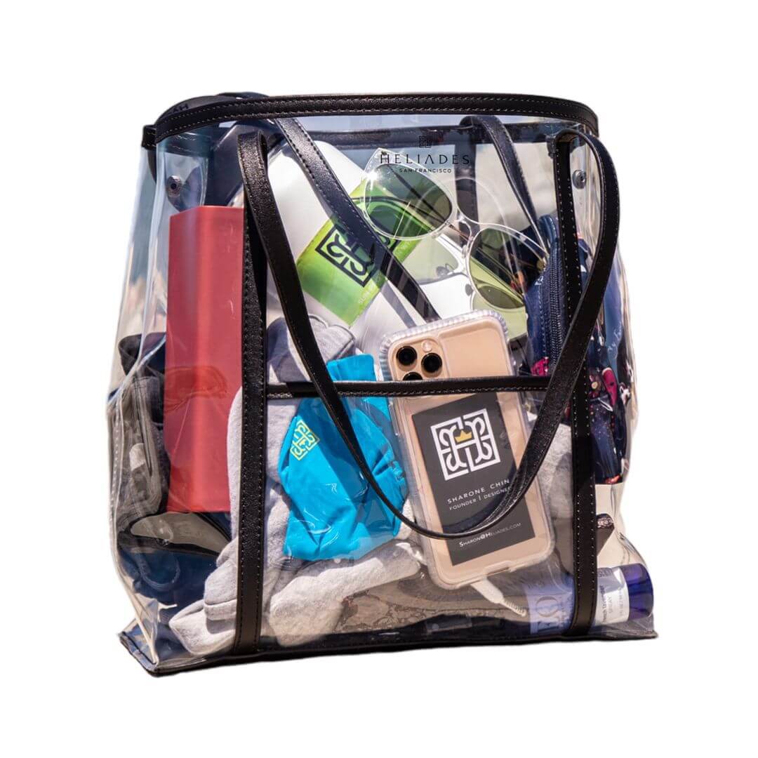 Heliades Designer Clear Bag 12x6x12 is Stadium Approved, made of durable .8mm thick TPU with sewn seams shown filled with water bottle, UV Gloves, Sunglasses and more.