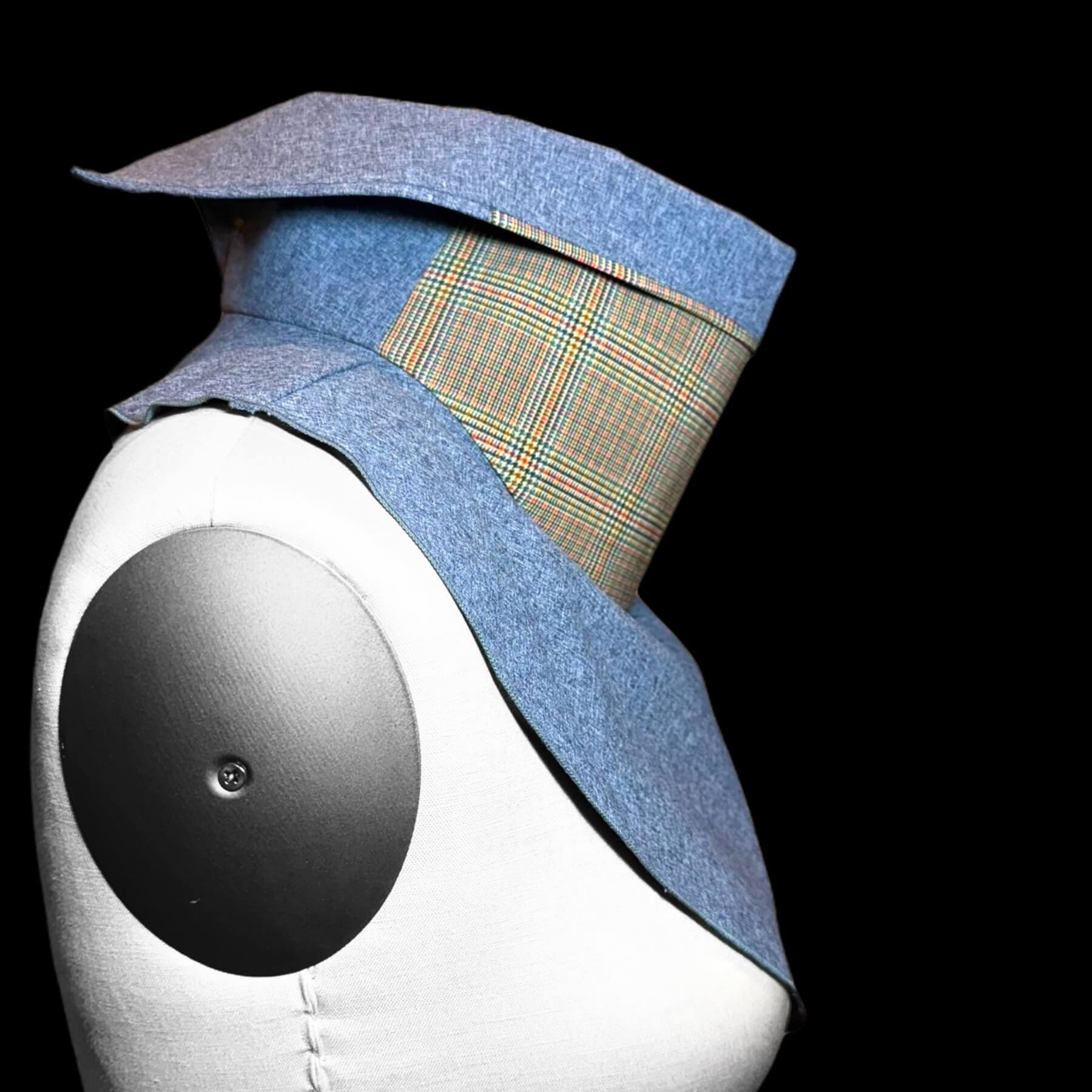 Side view of Sun Dickey with collar partially folded down is shown on a mannequin in blue melange with classic glenn plaid print in shades of yellow, blue, orange and green