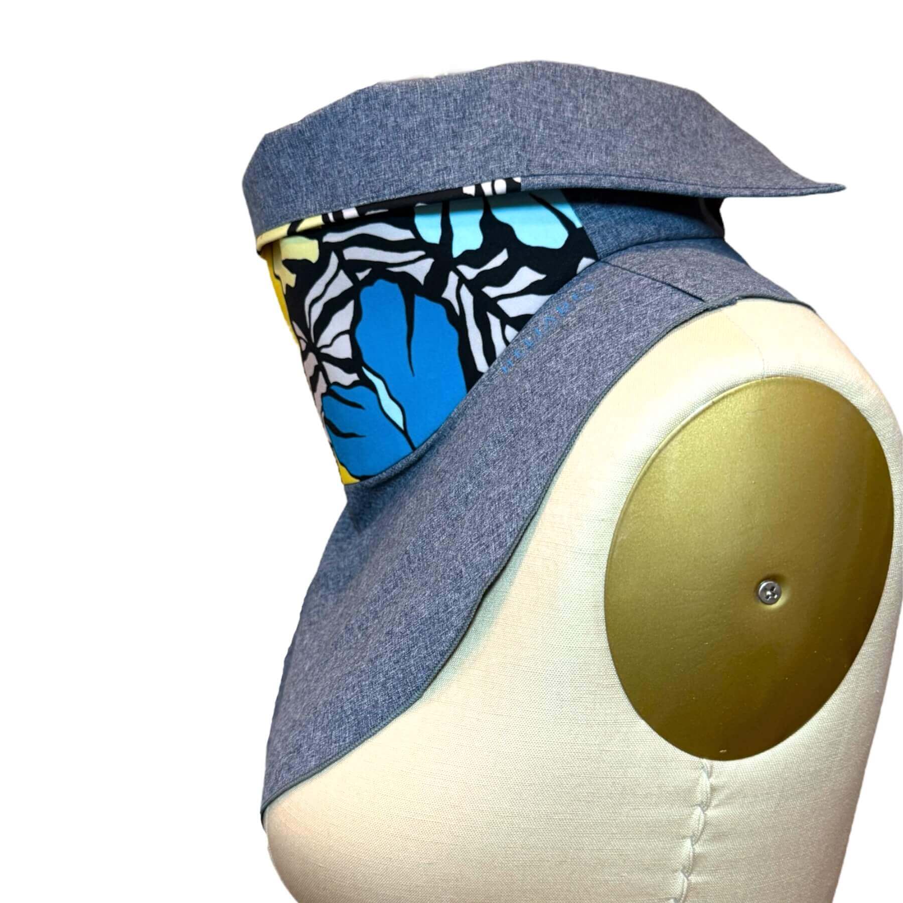 Side view of Sun Dickey shown with collar turned down in blue melange with Hawaiian floral print in shades of blue, yellow, black and white