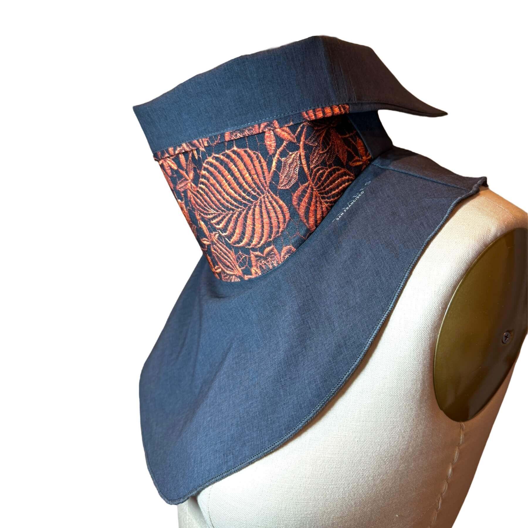 Side view of fashion Sun Dickey with collar folded down shown in charcoal gray melange with intricately detailed lace print in copper metallic on black.