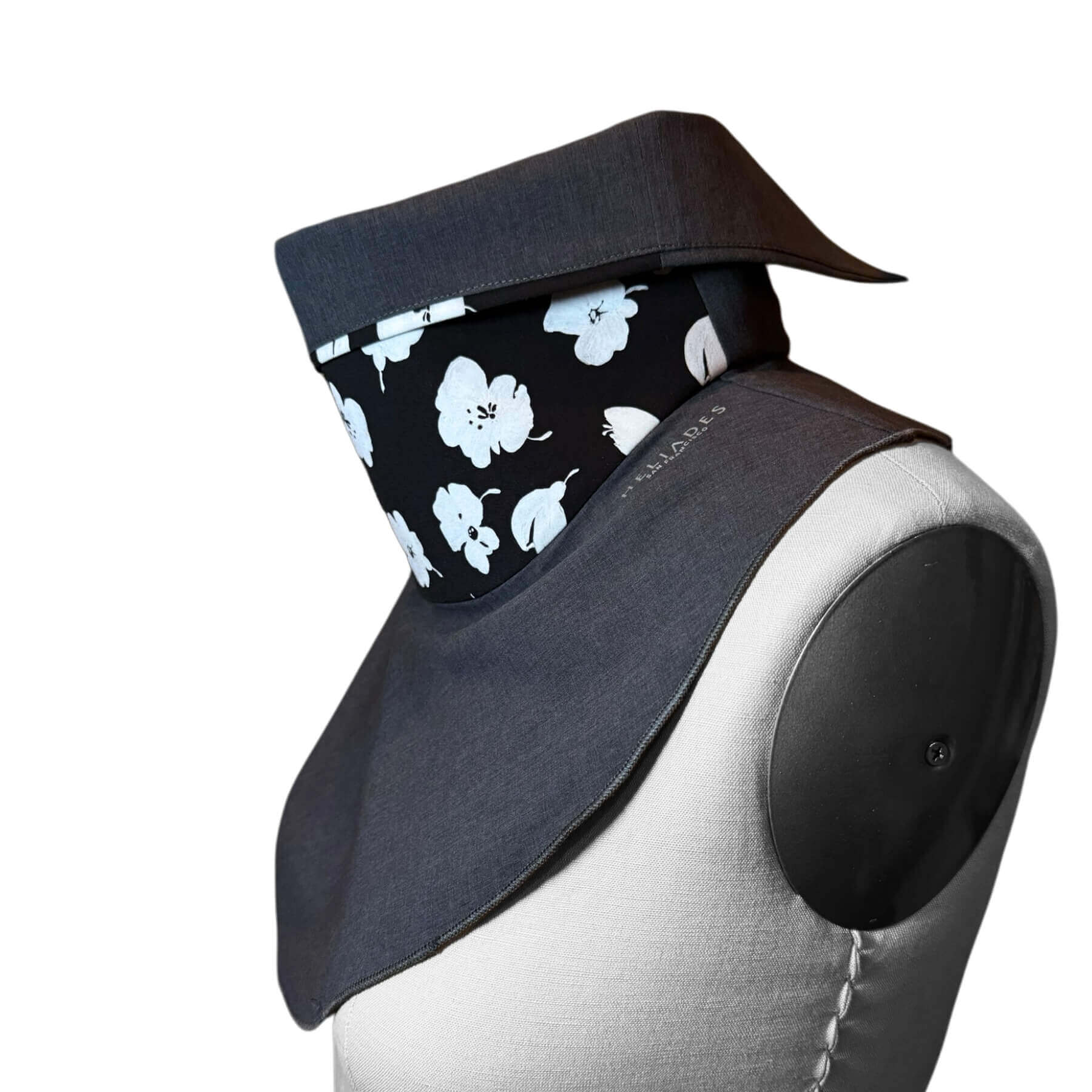Side view of stylish UV Sun Dickey shown on mannequin with contrast collar folded down in charcoal gray melange with white painted flowers on black.