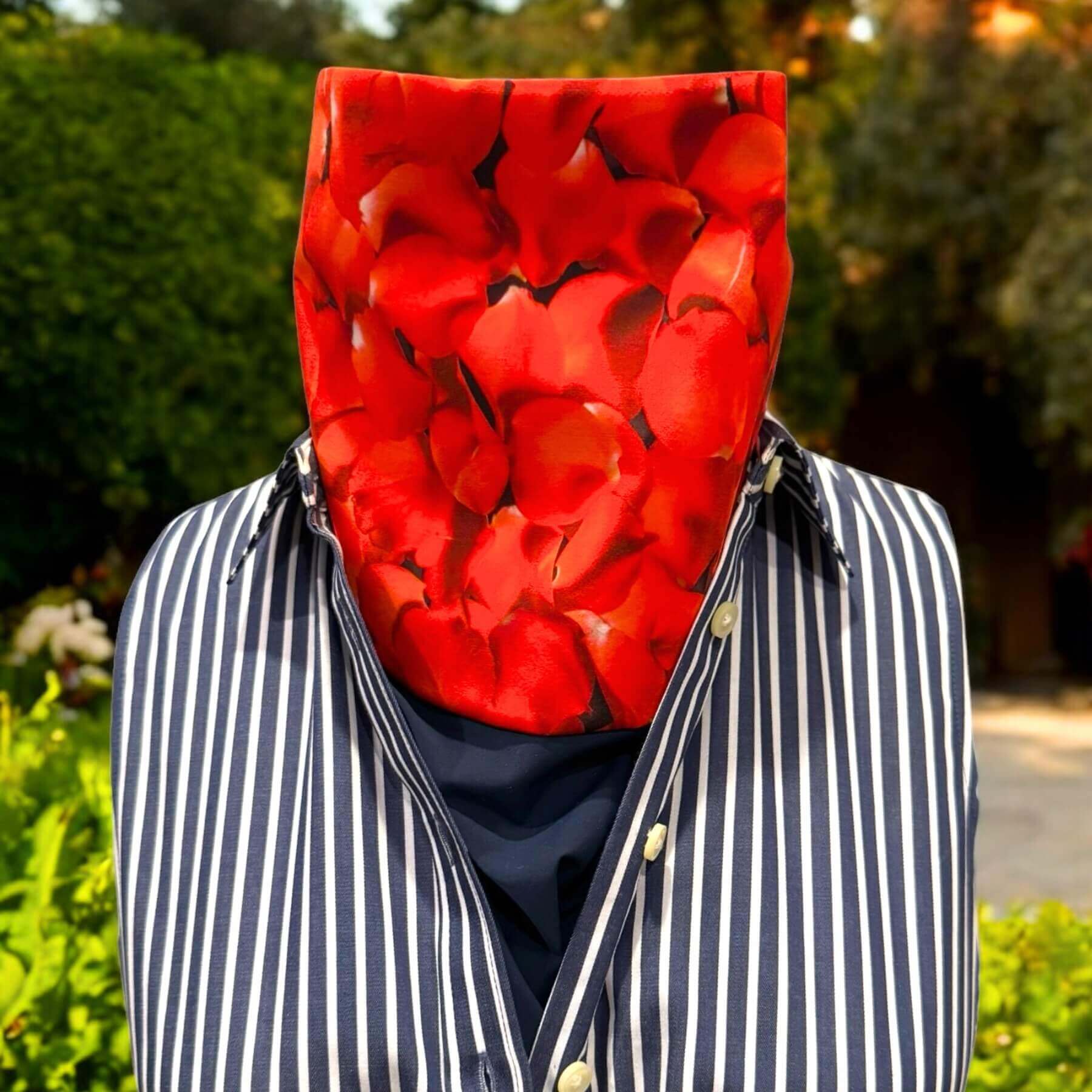 Elegant Sun Dickey shown in navy blue with red hydrangea petal print paired with navy blue and white vertical striped dress shirt. In background is yard with trees, dirt and green bushes