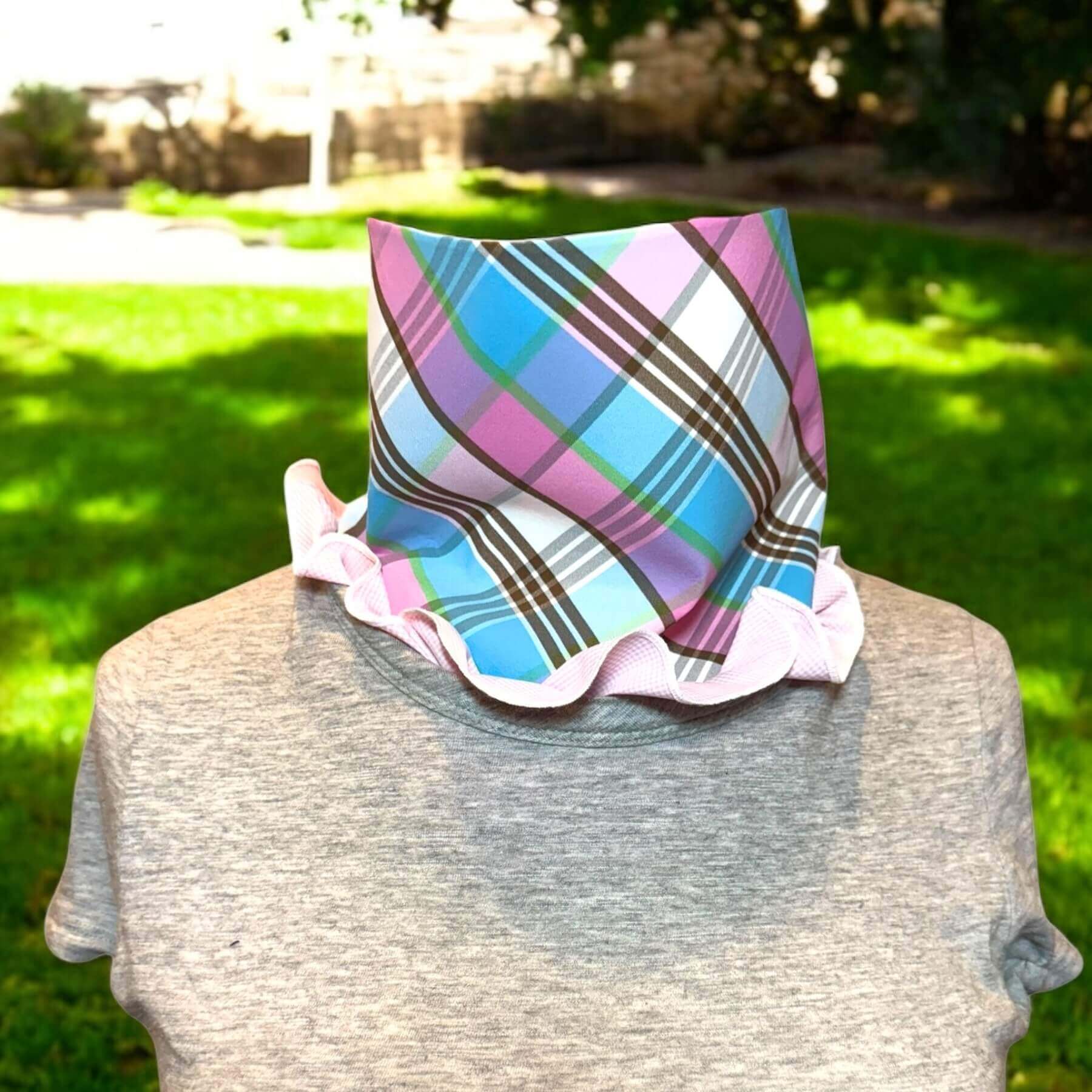 Sun Dickey shown in pink, white micro check with pink, blue, green and white plaid. Dickey is styled with the dickey ruffled around the collar of a gray t-shirt. In background is parking lot, fence, grass and trees
