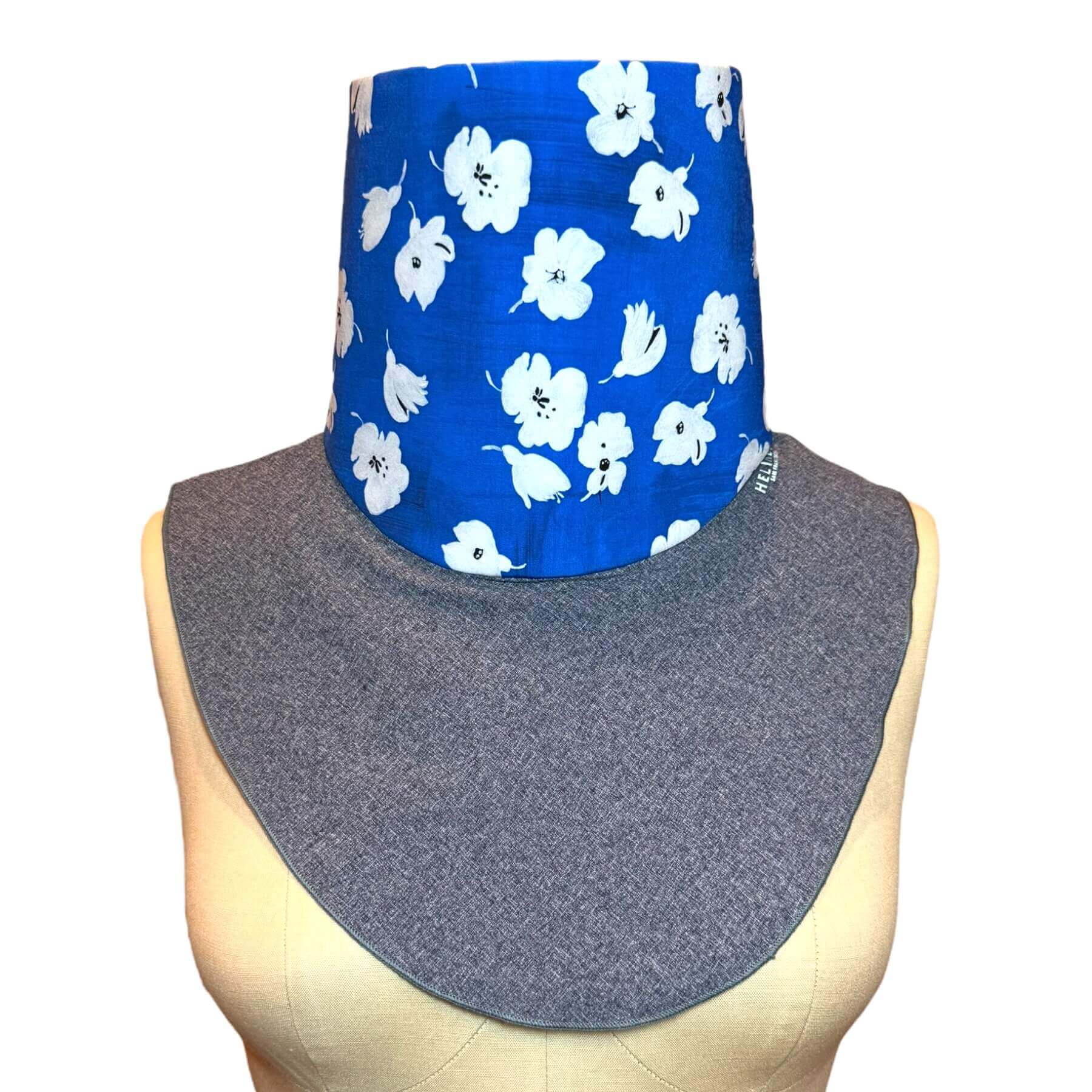 UV Neck Scarf-Fashion UPF 50+ Sun Dickey shown in Blue Melange with White, Black 'painted' flowers on brilliant sapphire blue fabric.