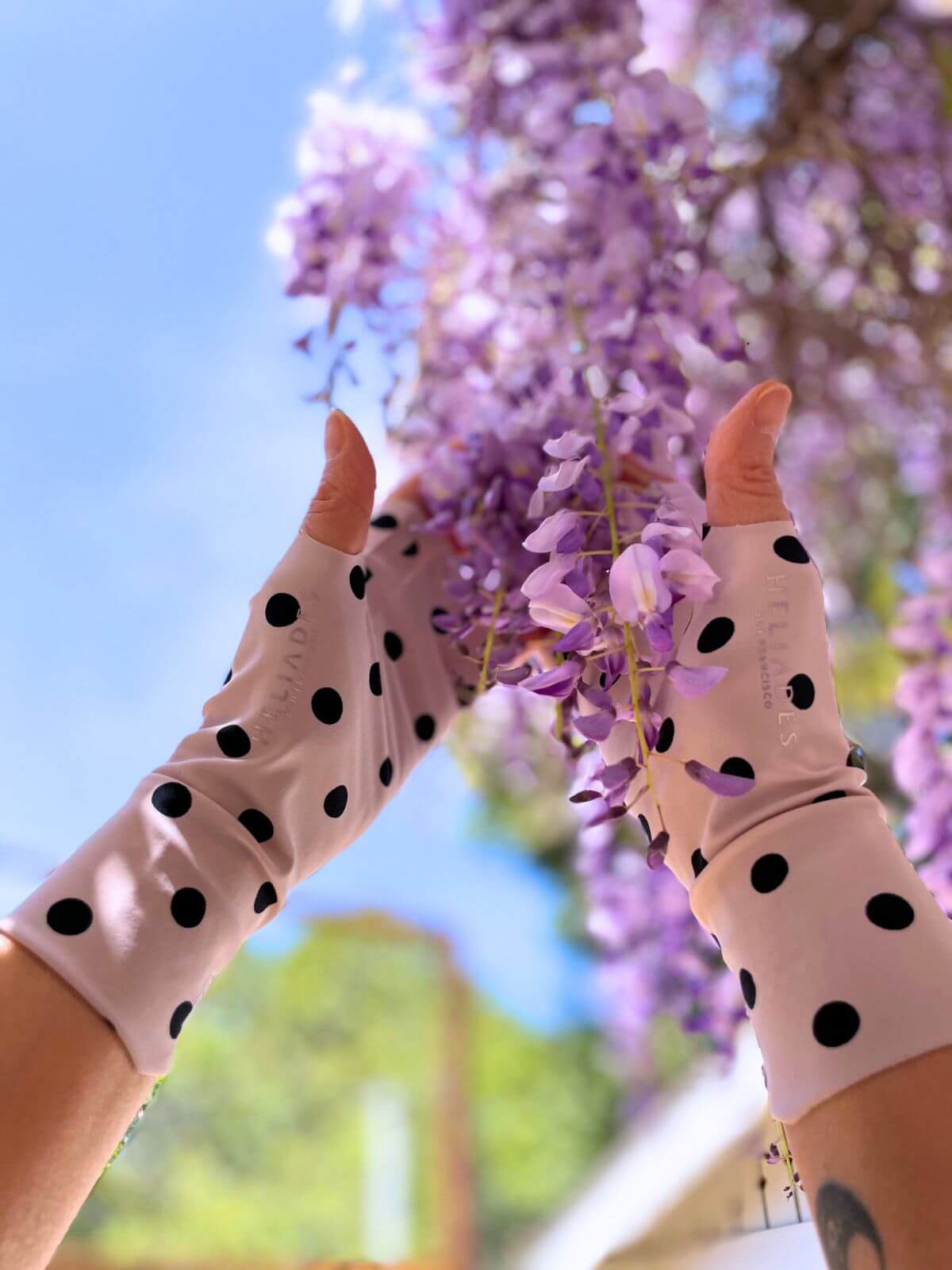 Heliades sun protection gloves in ballet pink polka dot with flowers, showcasing fashionable UV protective clothing for women.