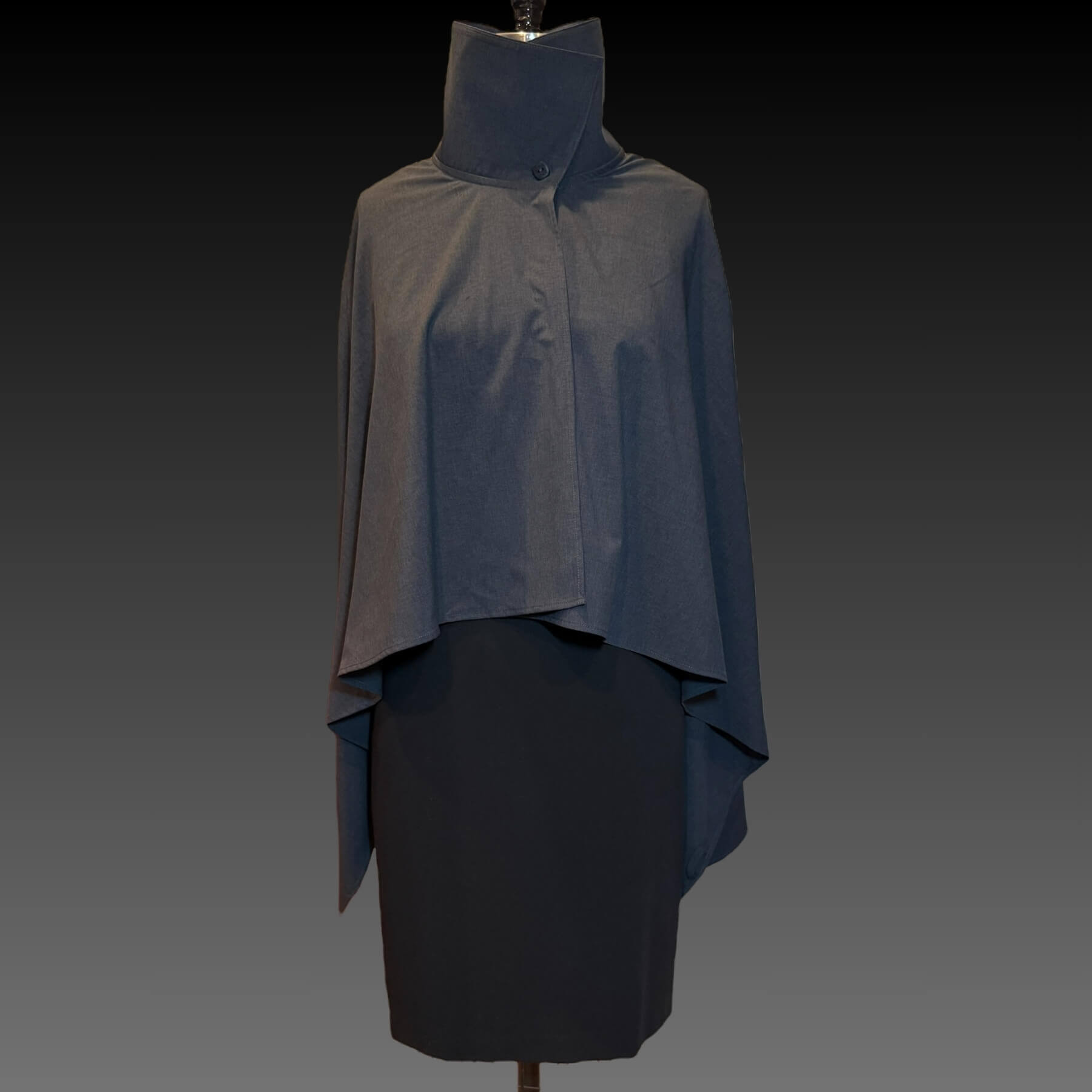 Front view of the Gray Melange Sun Shawl in UPF 50+ fabric, shown buttoned at the collar with collar up. Styled on a mannequin wearing a black dress against a black gradient background.
