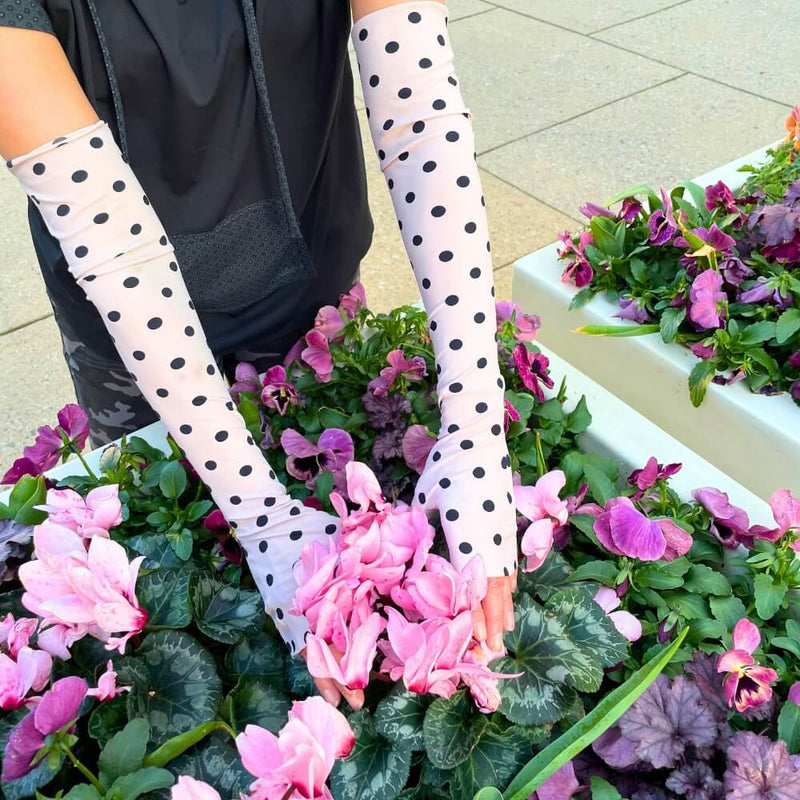 Woman wearing Heliades UPF 50+ Sun Gauntlets in ballet pink polka dot print