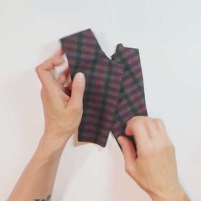 Putting on black, pink plaid Heliades UV gloves for driving to protect hands from sun damage