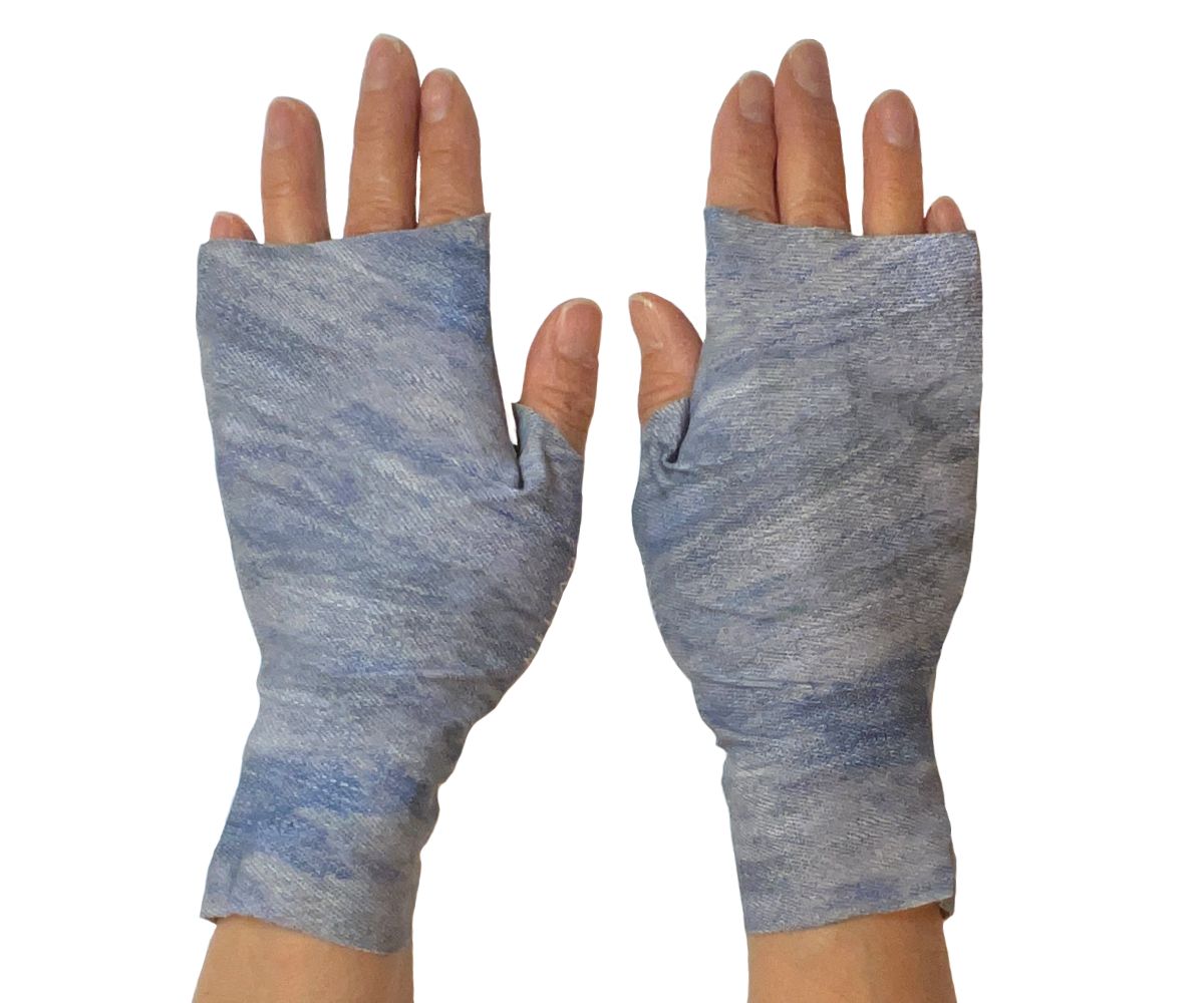 Heliades Sun Protective Clothing lightweight UV sun gloves in stylish patterned UPF 50 fabric. Shown is fashionable allover denim jeans print with shades of blues, white and gray  colors. UV sun covered hands shown front