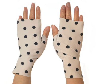 Heliades Sun Protective Clothing lightweight UV sun gloves in stylish patterned UPF 50 fabric. Shown is fashionable polka dot print with ballet pink and black colors. UV sun covered hands shown front