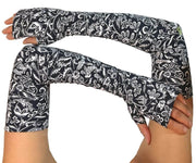 Heliades UPF 50 Sun Protective Clothing UV Arm Sleeves in fashionable, elegant allover navy blue and white floral print. UV sun covered arms and hands shown folded in front.