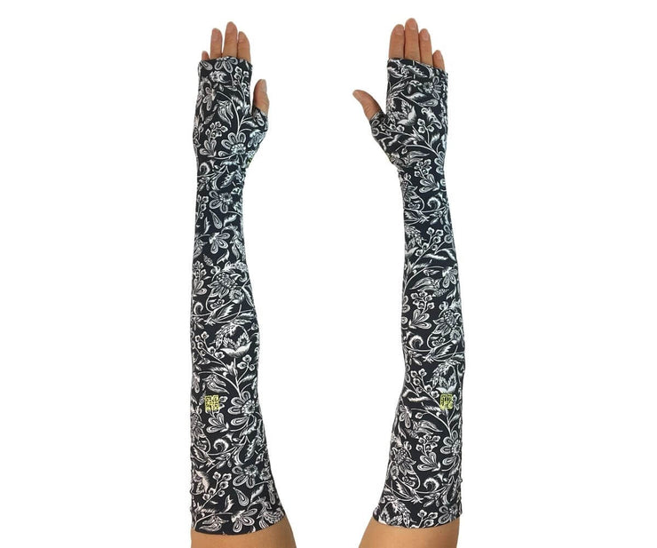 Heliades UPF 50 Sun Protective Clothing UV Arm Sleeves in fashionable, elegant allover navy blue and white floral print. UV covered arms and hands shown outstretched.
