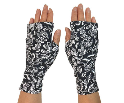 Heliades UPF 50 Sun Protective Clothing UV sun gloves on pattern fabric. Shown is fashionable, elegant allover navy blue, white floral print. UV sun covered hands shown front