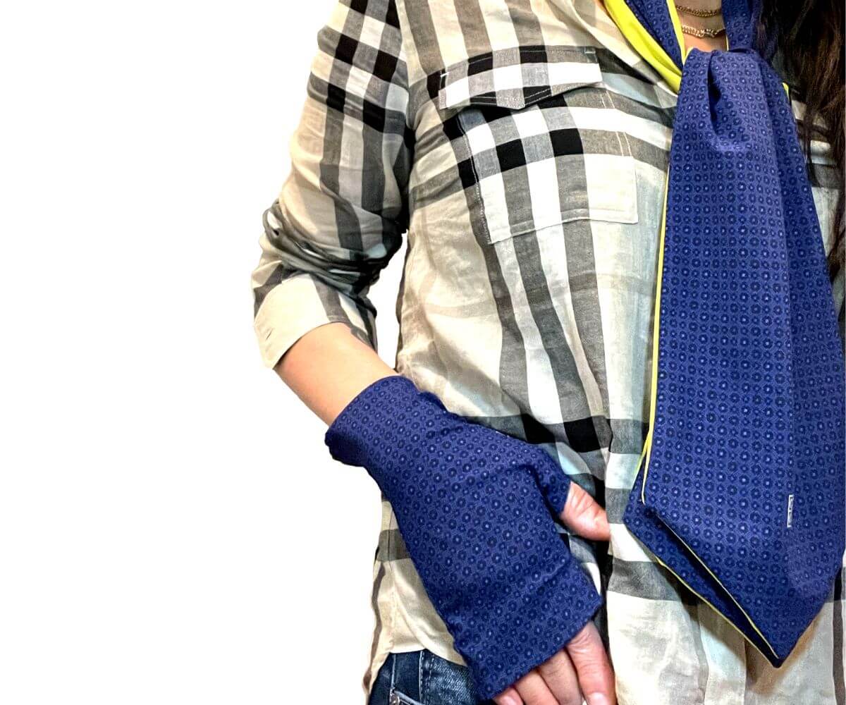 Heliades UPF 50 Sun Protective Clothing lightweight UV sun gloves and double sided cravat scarf in stylish patterned fabric. Shown is fashionable, elegant, unisex rosette print with tanzanite, blue, black colors. Bright yellow color on scarf reverse 