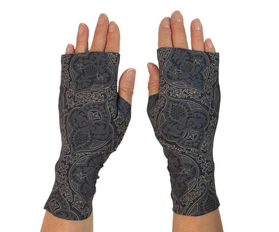 Heliades UPF 50 Sun Protective Clothing lightweight UV sun gloves in stylish patterned fabric. Shown is fashionable, elegant allover print with charcoal gray, black and gold colors. UV sun covered hands shown front