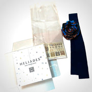 Easy, elegant DIY gift packaging kit shown partially assembled with clear cellophane bag, upcycled fabric ribbon cut from repurposed HELIADES fabric, branded clear packaging insert and two temporary tattoos. Blue and burgundy spirit flower sold separately.