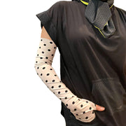 HELIADES UPF50+ sun protective full length arm sleeves in soft ballet pink with black polka dot all over print. Covers hands, fingerless, tagless, seamless. UPF 50+ sun protective black hoodie shown with gray with gold sparkle UV sun cravat for neck coverage. All fabric 98% UV blocking and OEKO-TEX certified.