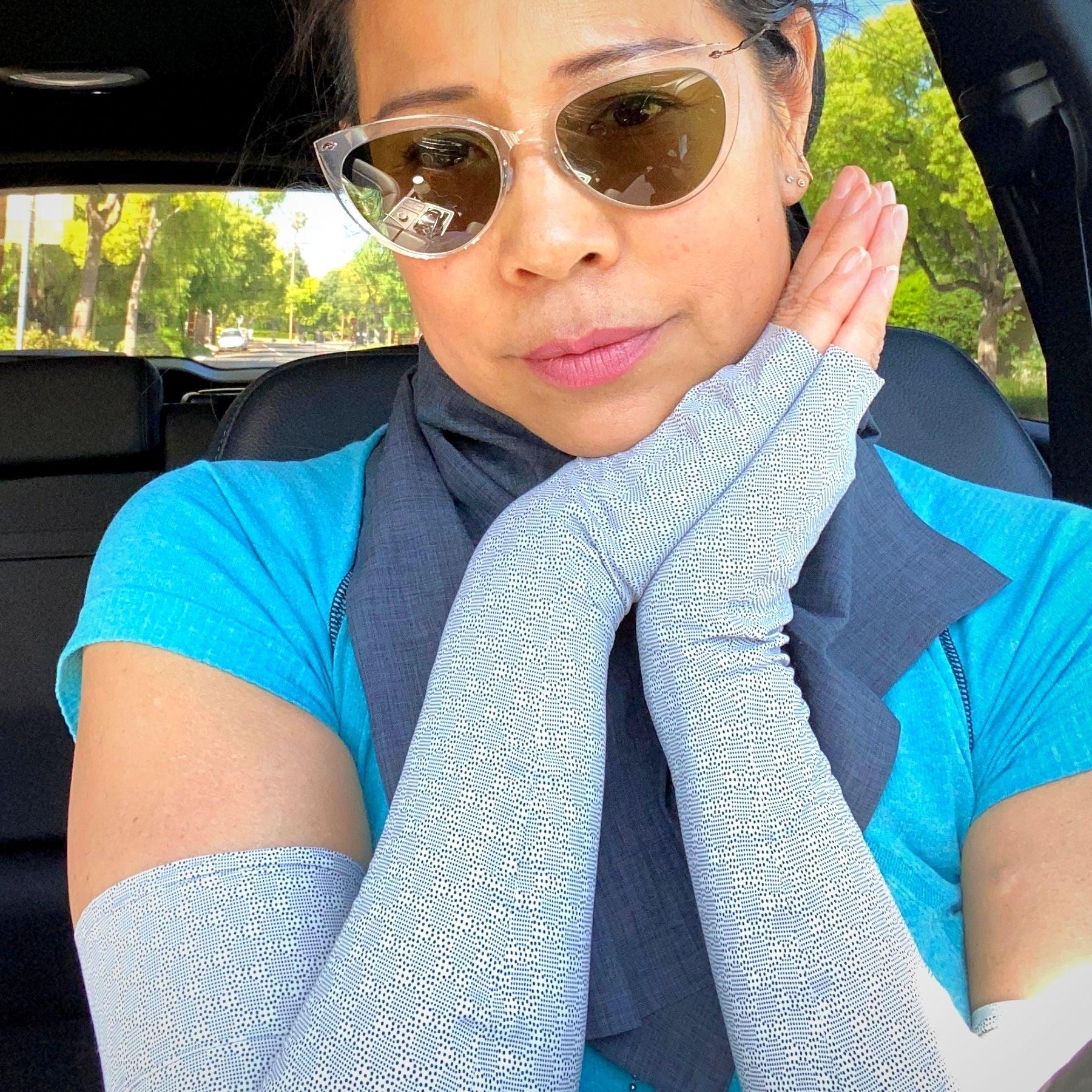 Woman holding hands together wearing UPF 50+ sun protection arm sleeves in creamcircles print - a neutral beige with allover black dotted circles print